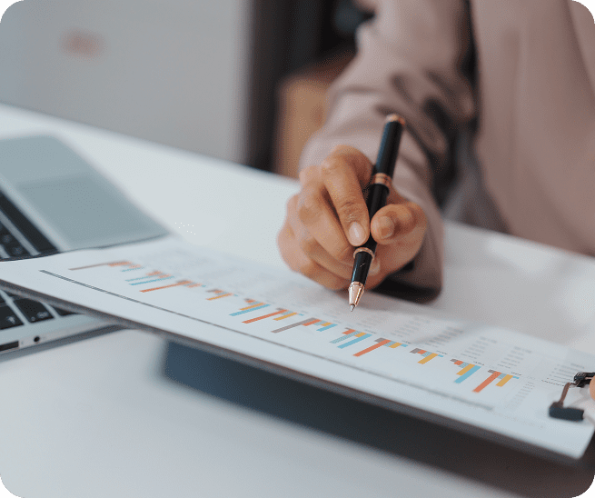 Hand analyzing financial graph with pen.